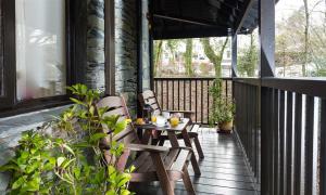 a patio with two chairs and a table on a porch at River Falls View in Ambleside