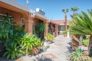 a hotel with a courtyard with palm trees and plants at Economy Inn Los Banos in Los Banos