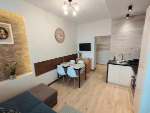 ein Wohnzimmer mit einem Tisch und Stühlen sowie eine Küche in der Unterkunft Apartamenty A&B Gold in Kalisz