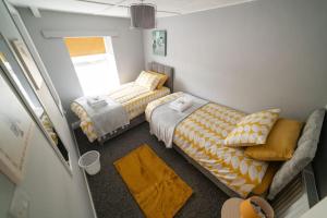 um pequeno quarto com 2 camas e um sofá em 2 Bed Sleeps 4 Central Haverfordwest Town House em Pembrokeshire