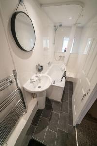 y baño con lavabo, bañera y espejo. en 2 Bed Sleeps 4 Central Haverfordwest Town House, en Pembrokeshire