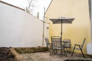 a patio with a table and chairs and an umbrella at 2 Bed Sleeps 4 Central Haverfordwest Town House in Pembrokeshire