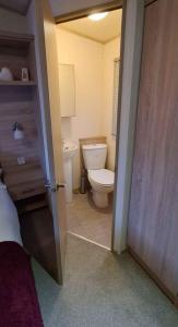 a bathroom with a toilet and a door open at 180 Golden Gate North Wales in Abergele