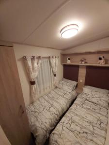 una camera con letto in una stanza con tende di 180 Golden Gate North Wales ad Abergele