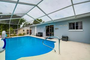 een groot zwembad met een glazen dak bij Stunning Nature Coast FL Salt Water Pool Getaway in Spring Hill