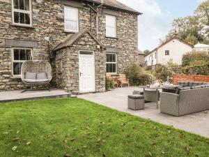 a stone house with a patio and a lawn at Raisthwaite Farm in Broughton in Furness