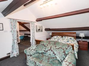a bedroom with a bed and a couch at Raisthwaite Farm in Broughton in Furness