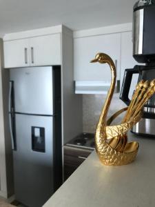 una estatua de cisne de bronce sentada en un mostrador en una cocina en SUITES EMPORIUM, en Guayaquil