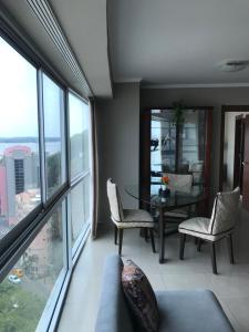 sala de estar con mesa, sillas y ventanas en SUITES EMPORIUM, en Guayaquil