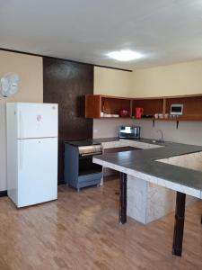 a kitchen with a white refrigerator and a counter at Cabana con Vista al Mar in La Bocana