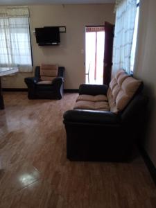 sala de estar con sofá y 2 sillas en Cabana con Vista al Mar, en La Bocana