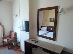 - une chambre avec un miroir, un lit et une chaise dans l'établissement Susanna Hotel Luxor, à Louxor