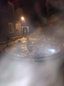 a group of people in a hot tub at night at Agroturystyka,, Ranczo Kruszynki" in Stronie Śląskie