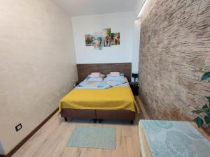 ein Schlafzimmer mit einem Bett und einer Ziegelwand in der Unterkunft Apartamenty A&B Gold in Kalisz