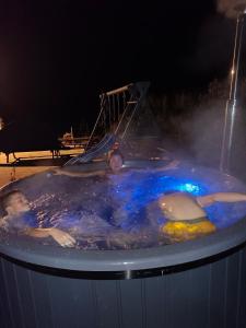 two people swimming in a hot tub at night at Agroturystyka,, Ranczo Kruszynki" in Stronie Śląskie