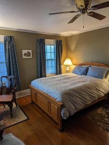 um quarto com uma cama e uma ventoinha de tecto em English Cottage em Greensboro