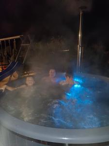 a group of people in a hot tub at night at Agroturystyka,, Ranczo Kruszynki" in Stronie Śląskie