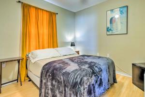 a bedroom with a bed and an orange curtain at Cute Pensacola Townhome about 9 Mi to Downtown! in Pensacola