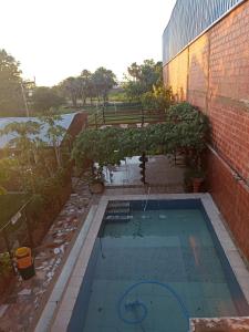 a swimming pool next to a brick building at Departamentos Temporarios Aeropuerto in Formosa