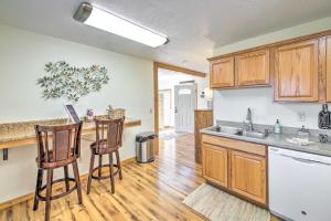 a kitchen with wooden cabinets and two bar stools at Cozy Cottage Studio Stunning Mountain Views! in Hamilton