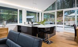 Una cocina con mesa y sillas y ventanas. en Tall Trees, en Bowness-on-Windermere