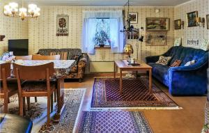 a living room with a blue couch and a table at Beautiful Home In Lnneberga With 2 Bedrooms in Lönneberga