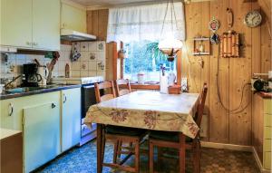 a kitchen with a table and chairs and a kitchen with wooden walls at Beautiful Home In Lnneberga With 2 Bedrooms in Lönneberga
