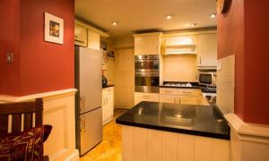 a kitchen with white cabinets and a black counter top at Priory Lodge in Windermere