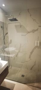 a bathroom with a glass shower and a sink at Strada-Beach Las Canteras in Las Palmas de Gran Canaria