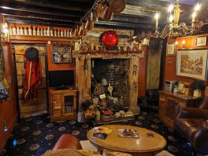 a living room with a couch and a table at Wizards Thatch Medieval Styled Suites with Four Poster Beds in Alderley Edge