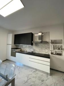 uma cozinha com armários brancos e piso em mármore em Centoventinove em Carrara