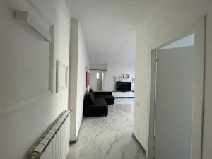 a living room with a black couch and a hallway at Centoventinove in Carrara +1 photo