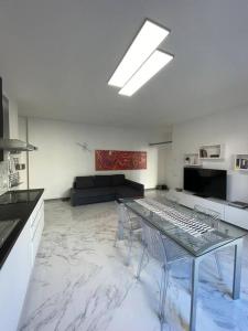 uma sala de estar com uma mesa de vidro e um sofá em Centoventinove em Carrara