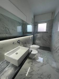 uma casa de banho com um lavatório e um WC em Centoventinove em Carrara