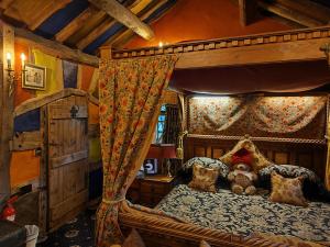 a bedroom with a canopy bed with a teddy bear on it at Wizards Thatch Luxury Suites in Alderley Edge