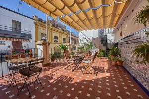 a patio with tables and chairs under a yellow umbrella at Casa Pureza in Seville