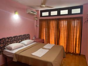 - une chambre avec un lit et une fenêtre avec des rideaux dans l'établissement Hotel Samudra Tara, à Kovalam