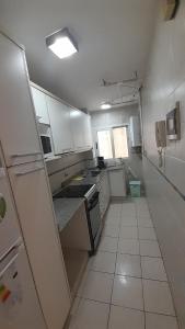 una pequeña cocina con armarios y electrodomésticos blancos en departamento en recoleta en Buenos Aires