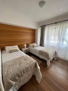 a bedroom with two beds and a window at Hermoso departamento en playa Frutillar Bajo in Frutillar