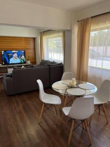 a living room with a table and chairs and a couch at Hermoso departamento en playa Frutillar Bajo in Frutillar