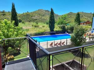 a balcony with a view of a swimming pool at Posada Valle del Sol in Potrero de los Funes