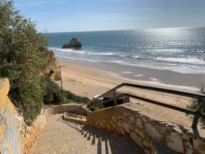 a staircase leading to a beach with the ocean at ConVistaApartment with Pool in Portimão