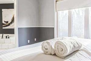 sypialnia z łóżkiem z dwoma ręcznikami w obiekcie Cheerful 4 bedroom home with inground heated pool w mieście Prévost