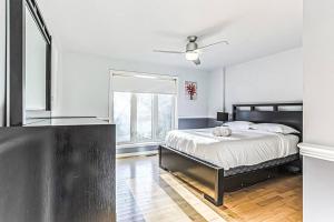 biała sypialnia z łóżkiem i oknem w obiekcie Cheerful 4 bedroom home with inground heated pool w mieście Prévost