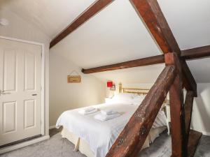 a bedroom with a large bed with white sheets at Candleberry Cottage in Ambleside