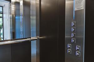 un ascensor con una puerta de metal con los números en él en Garni hotel BARUT, en Šabac