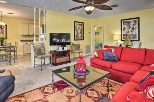 a living room with a red couch and a table at Nokomis Home with Gas Grill 2 Blocks to Beach! in Nokomis