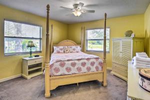 a bedroom with a canopy bed and two windows at Nokomis Home with Gas Grill 2 Blocks to Beach! in Nokomis