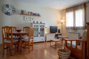 a living room with a dining room table and a television at Apartament Cadí- Moixeró in Bagá