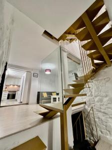 a staircase in a living room with a stone wall at Vivienda Casa Gabi in Úbeda